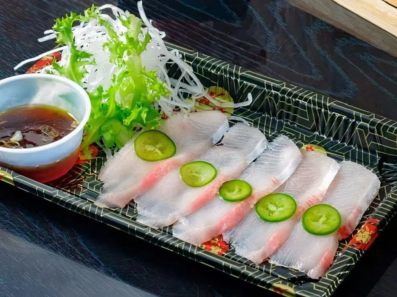 Slices of fresh white fish sashimi with condiments at Hana Sushi & Asian Cuisine, a Asian Restaurant in Maplewood